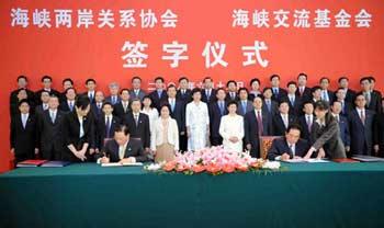 Chen Yunlin, chairman of Chinese mainland's Association for Relations Across the Taiwan Strait (ARATS), and Chiang Pin-kun, chairman of the Taiwan-based Straits Exchange Foundation (SEF) sign the agreements on cross-Strait weekend charted flights and mainland tourists' traveling to Taiwan, in Beijing, China, June 13, 2008. (Xinhua Photo)