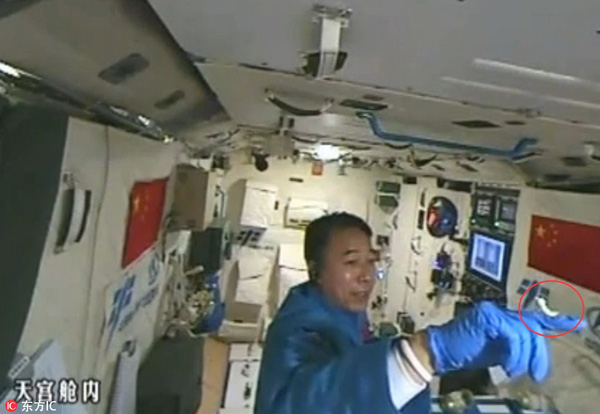 Astronaut plays with silkworms in Tiangong II