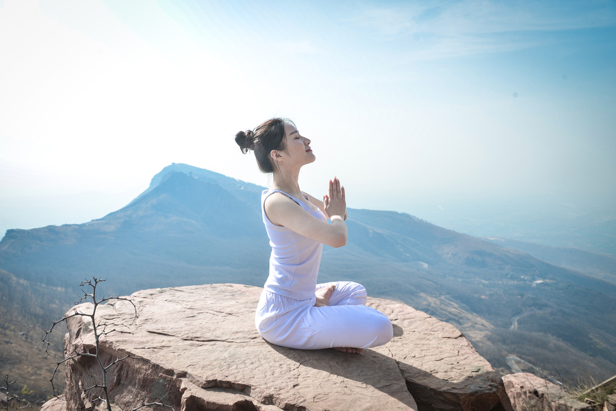 Striking yoga poses on top of cliff