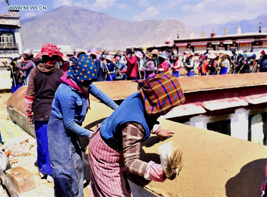 Craftswomen repair roof of Tibet monastery