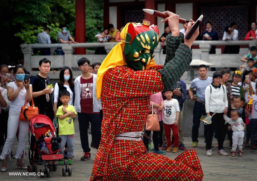 Tourists view Nuo dance at China's Yongcheng