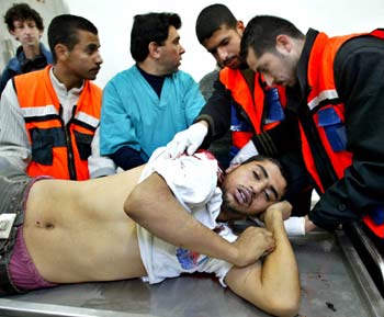 Palestinian medical staff examine the body of Mohammed Abu Nasser, who was shot during clashes with Israeli soldiers near the border between Israel and the Gaza Strip, at the Kamal Edwan hospital in the Jebalya refugee camp north of Gaza Strip, December 22,2004. British Prime Minister Tony Blair said on Wednesday his proposed London conference on Palestinian reform would be a critical step toward peace talks with Israel and an independent state. [Reuters]