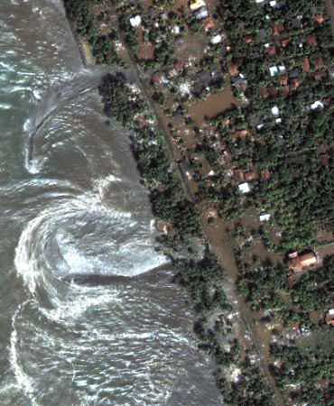 Swirling ocean swells are seen along the flooded coast of Kalutara, Sri Lanka in an image taken by DigitalGlobe's QuickBird satellite shortly after the area was hit by a Tsunami on December 26, 2004. Stricken Indian Ocean nations worked swiftly on December 28 to bury thousands of bodies as experts warned disease could kill as many people as the 60,000 already dead from the violent crush of Sunday's tsunami. [Reuters]