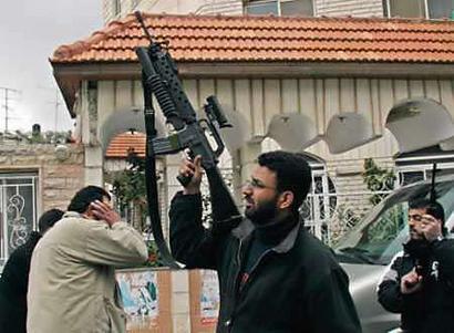 Armed Palestinian men fire shots into the air in front of a building where a Fatah meeting took place in the West Bank city of Ramallah March 10, 2005. Gunmen from the ruling Palestinian Fatah faction broke up a meeting of the party about reform on Thursday in a fresh blow to President Mahmoud Abbas's bid to end internal chaos and talk peace with Israel. [Reuters]