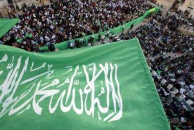 Palestinian supporters of the Islamic Resistance Movement Hamas wave flags during a rally in the West bank village of Taffouh near Hebron May 3, 2005. Palestinian police, enforcing a ceasefire with Israel, arrested two men from a suspected Hamas rocket squad after a gun battle in the Gaza Strip but freed the militants soon after, officials said on Tuesday. REUTERS