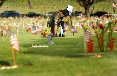 Mike Shane of Honolulu, a Vietnam veteran, kneels after finding the grave of medal of honor winner, Sgt. Leroy Mendonca before the Memorial Day Service at the National Memorial Cemetery of the Pacific, in Honolulu, Hawaii, May 30, 2005. Millions of flowers were used in placing leis on each of the more than 112 acres of graves. Also known as the 'Punchbowl' the National Memorial Cemetery of the Pacific lies in the middle of Puowaina Crater, an extinct volcano. It was officially dedicated on September 2, 1949, on the 4th anniversary of V-J Day. Overlooking Honolulu, the cemetery has been described as one of most beautiful national cemeteries in the country. REUTERS