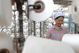 A Chinese woman works on a production line at a textile factory in Hefei, east China's Anhui province, August 30, 2005.