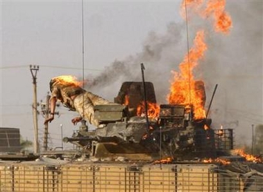 A British soldier jumps from a burning tank which was set ablaze after a shooting incident in the southern Iraqi city of Basra September 19, 2005.