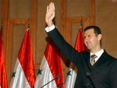 Syrian President Bashar Assad greets the audience at the Damascus University auditorium, where he delievered a political speech outlining all regional issues and the pressures facing Syria Thursday Nov. 10, 2005.