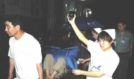 Chinese health workers carry a student, who gets injured during lightning, to a hospital in Kaixian County, Southwest China's Chongqing Municipality, May 23, 2007. Seven children were killed and 39 were injured on Wednesday afternoon when lightning struck their three-room school house in the village of Xingye in Kaixian County. Six students with serious injuries are still hospitalized, Xinhua News Agency reported on Friday. [Xinhua]