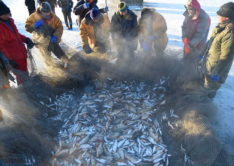 Winter fishing in ice-covered Hulun Lake in Inner Mongolia